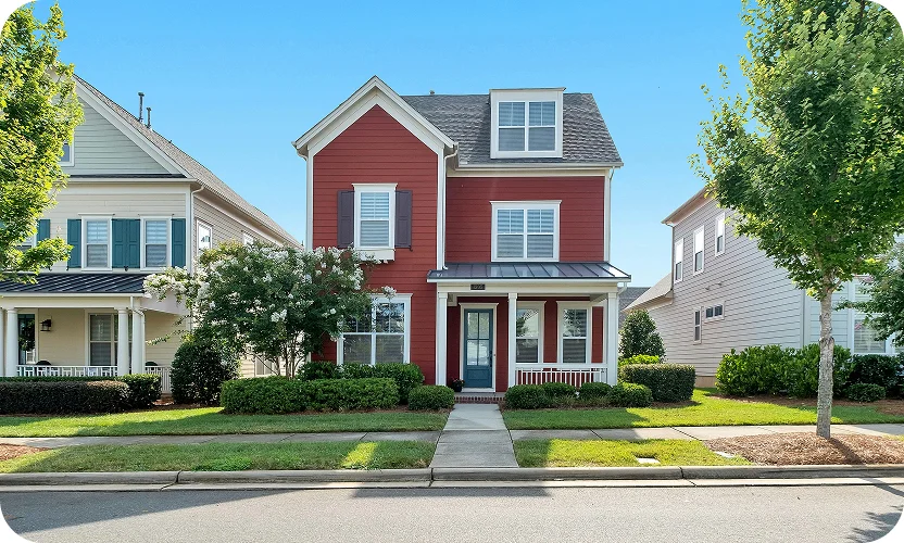Charming red suburban house with white trim and a small front yard.